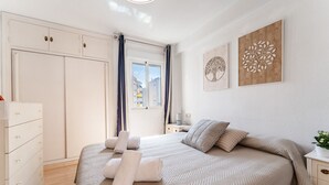 Ein Schlafzimmer mit einem Bett, einem Schminktisch, einem Nachttisch und Bildern an der Wand.