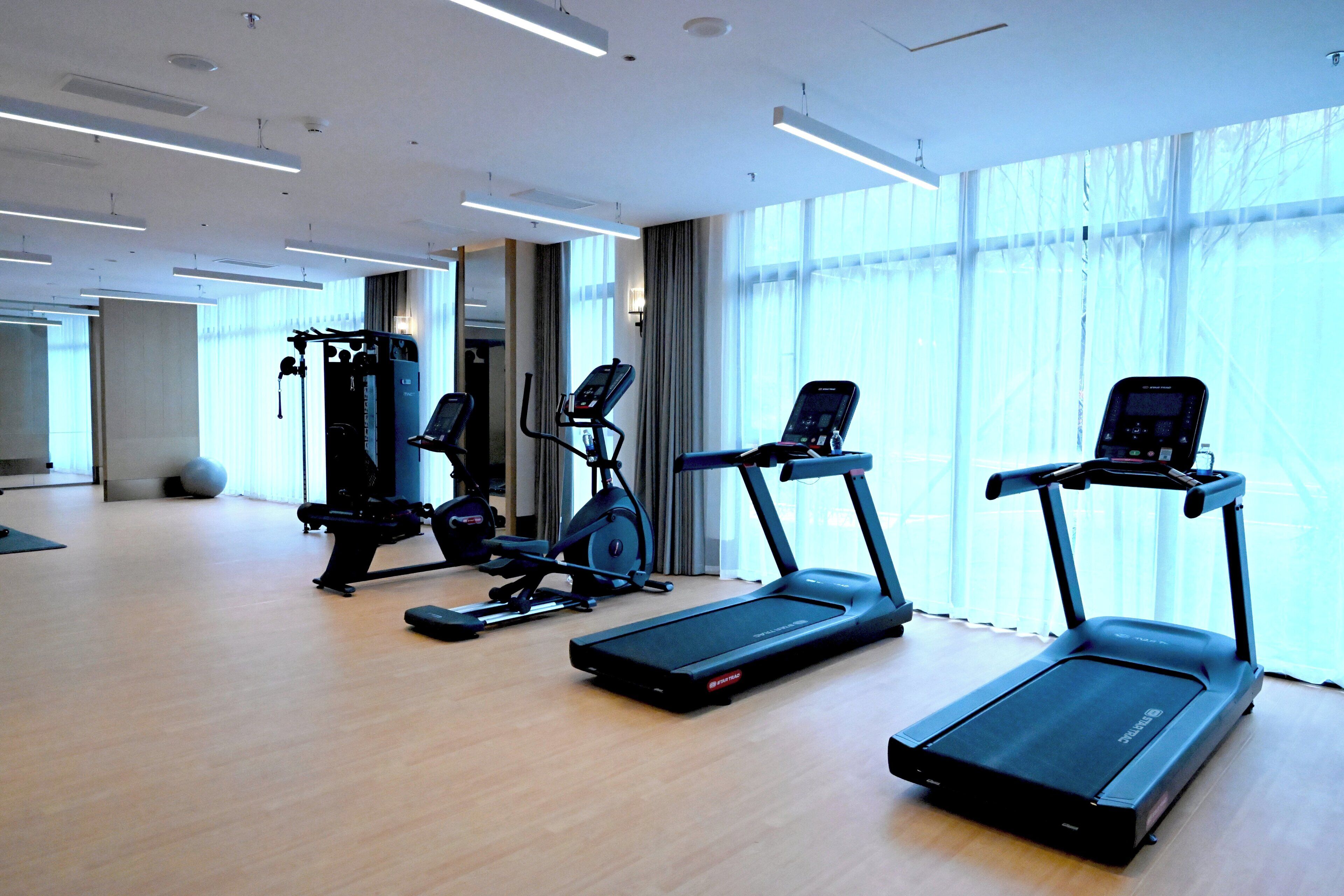 A gym with treadmills, an elliptical, and a weight machine.