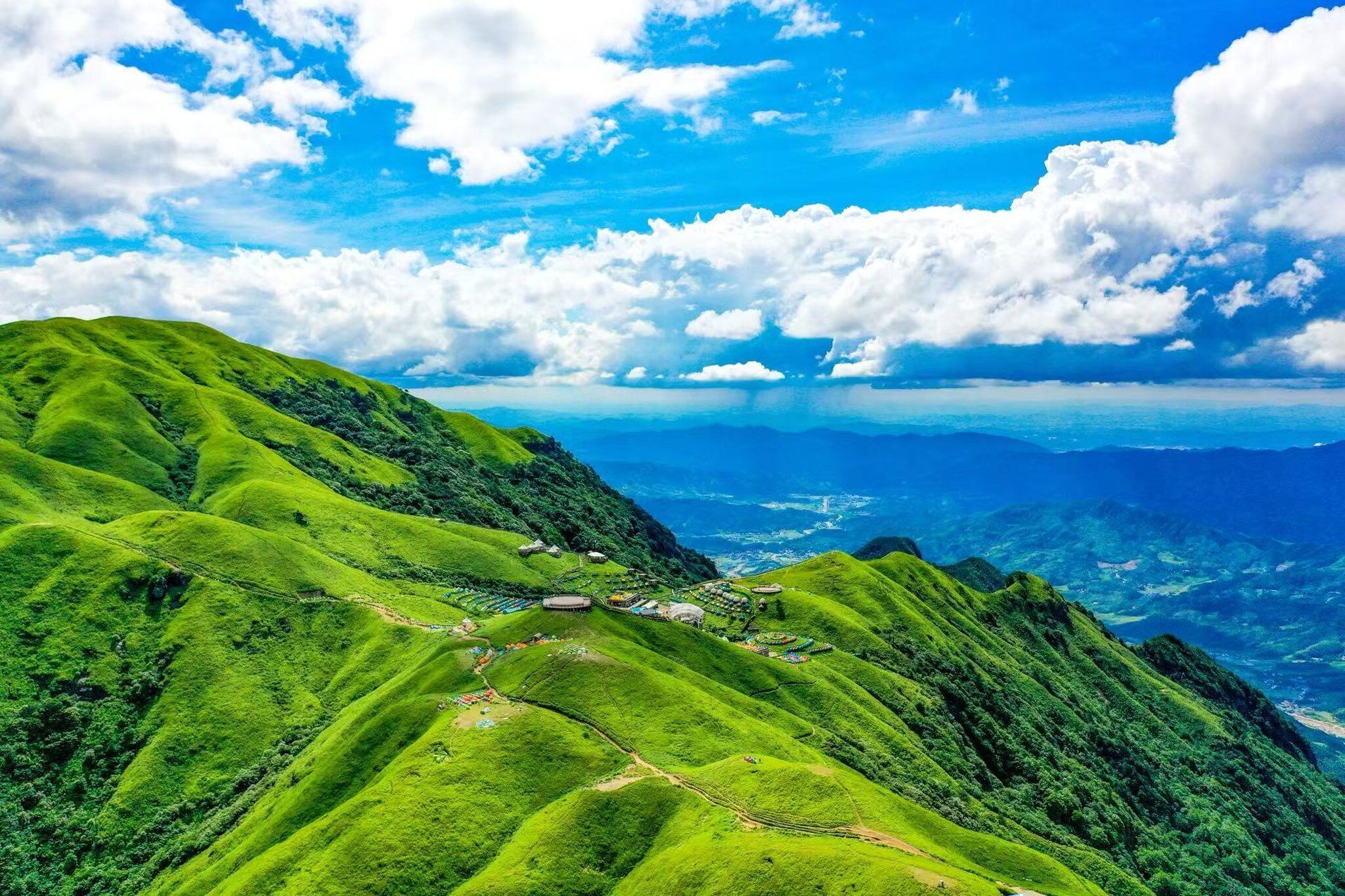 Un paisaje exuberante con colinas ondulantes y un cielo azul despejado.