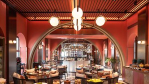 A buffet area with various food stations, seating arrangements, and a bar in the background. - Hotel Indigo Wuxi Qingming Bridge by IHG (Wuxi)