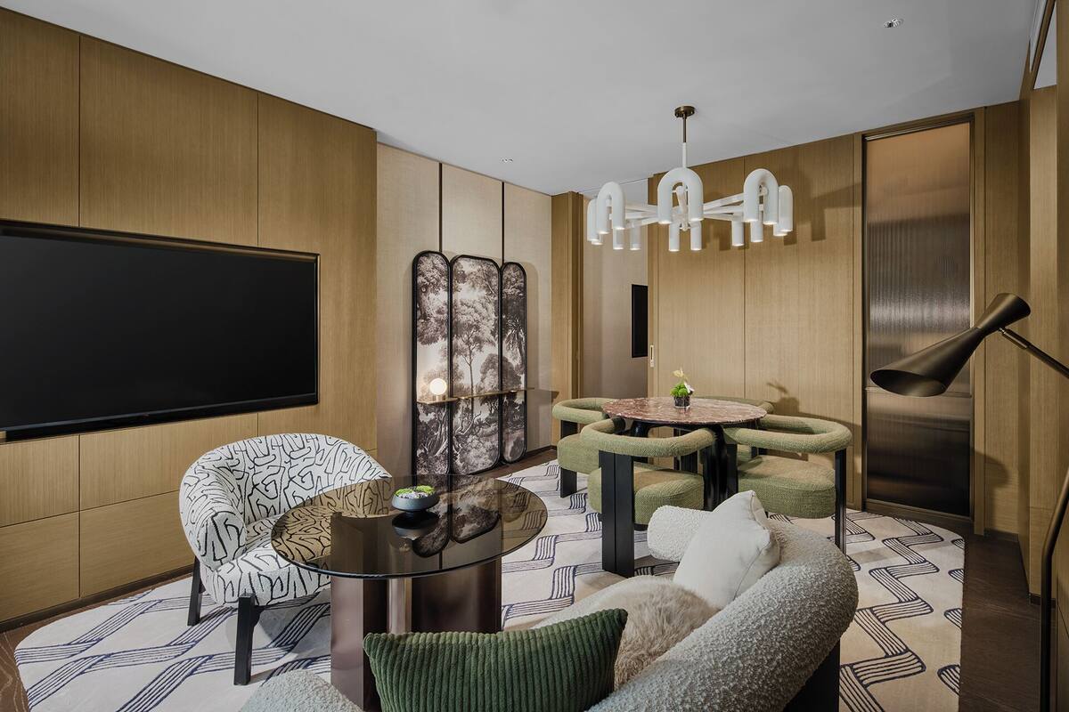 Un salon moderne avec un grand téléviseur à écran plat, une table basse ronde et un canapé.