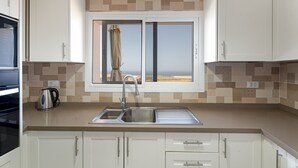 A kitchen with a window, a sink, and a kettle. - Holiday Home 'Elvira' with Sea View, Private Terrace and Wi-Fi (La Frontera)