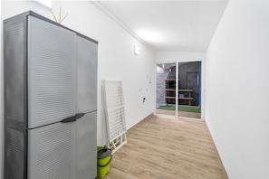 Un intérieur moderne avec un grand appareil électroménager, un mur blanc et une vue sur un espace extérieur.