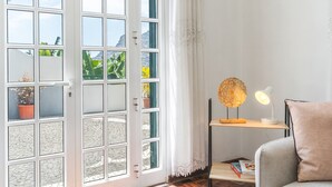 A room with a large window, a desk with a lamp, and a chair. - Casa do Pico by Atlantic Holiday (Camara de Lobos)