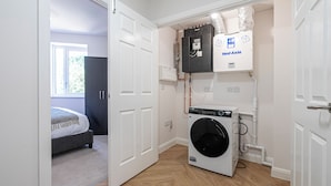 A laundry room with a washing machine, a dryer, and a water heater. - Quiet Luxe Escape 65s Only (Surrey)