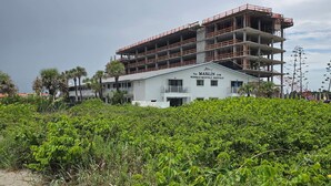 A building under construction with a sign for 'The Marlin' indicating weekly-monthly rentals. - Unit # 321 (Cocoa Beach)