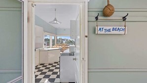 Eine Küche mit Schachbrettfußboden, einer Hängeleuchte und einem Schild mit der Aufschrift 'AT THE BEACH'.