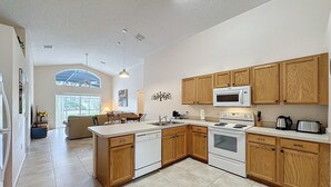 A spacious kitchen with wooden cabinets, a central island, and modern appliances.