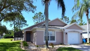 A single-story house with a front porch, a garage, and a well-maintained lawn. - South Facing Updated Southern Dunes Villa (Haines City)