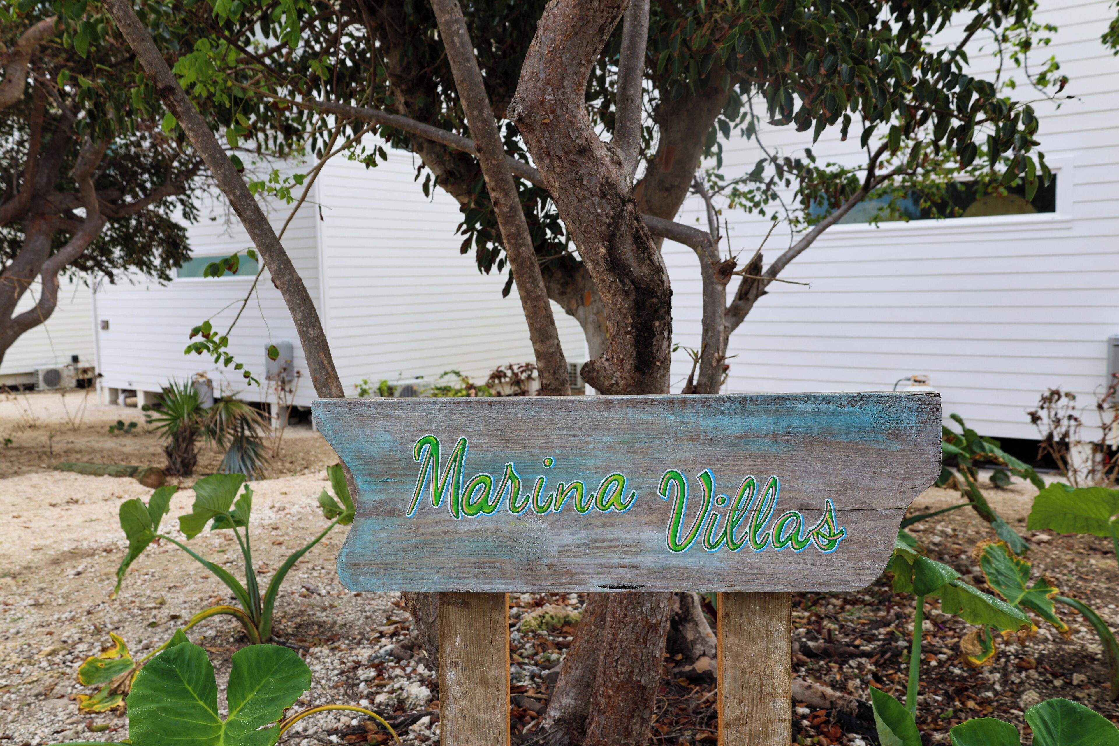 Et træskilt med teksten "Marina Villas" i rustik stil.