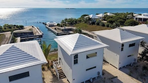 A coastal property with white buildings, a dock, and a view of the sea. - Kalopsia Seaside Villas & Marina (Great Guana Cay)