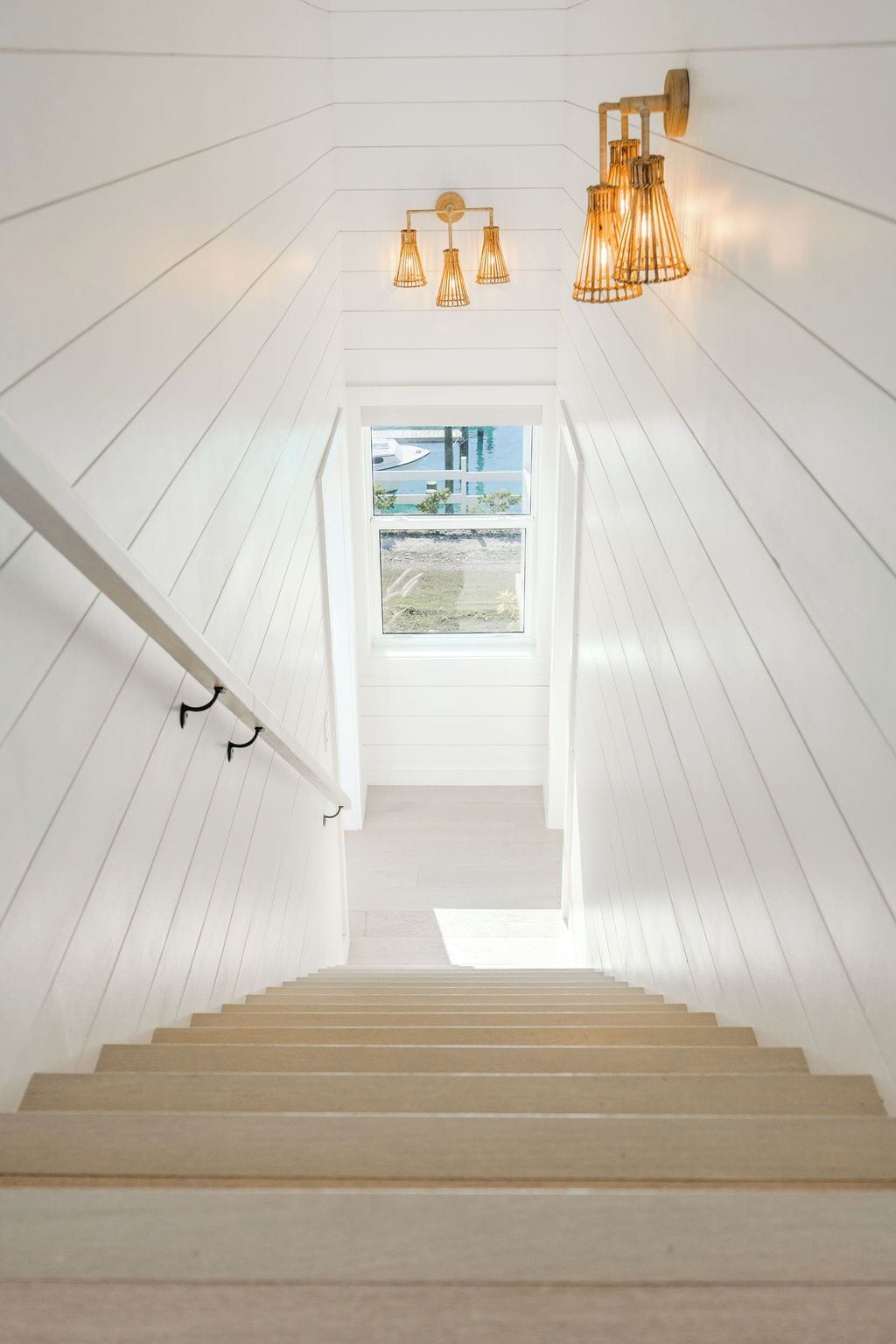 A staircase leading to a loft bedroom with a view of the water.