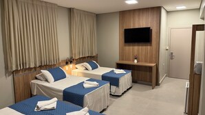 A hotel room with two beds, a TV mounted on the wall, and a wooden panel design. - Hotel Mato Grosso Inn (Cuiabá)