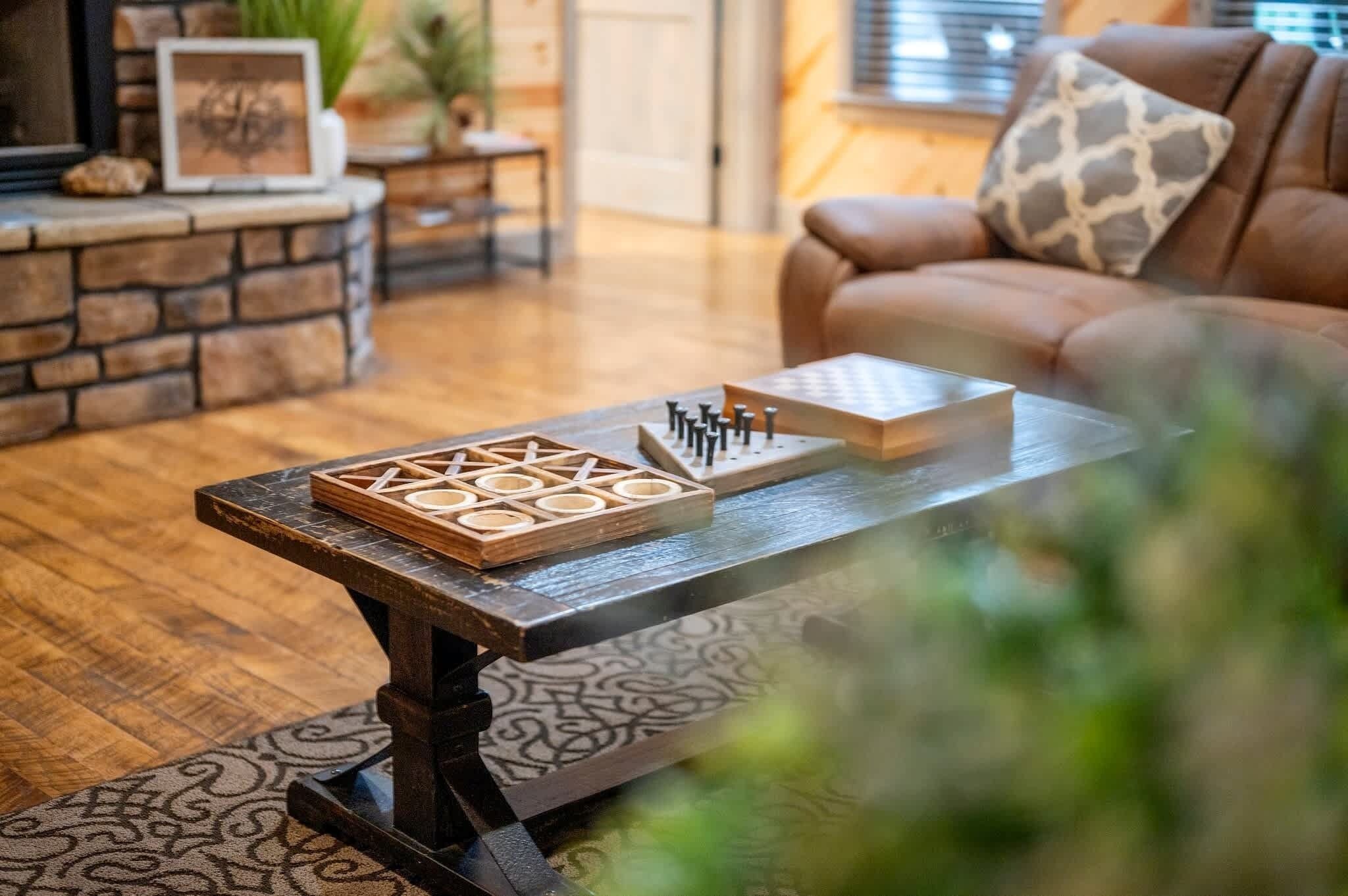 Ein Wohnzimmer mit Couch, Kamin, Holz-Couchtisch und einem gemusterten Teppich.