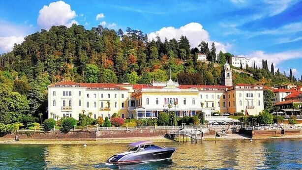 A waterfront hotel with a large building, a bell tower, and a boat dock. - Elegant Apartment in the Heart of Bellagio (Bellagio)