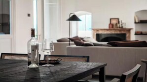 A dining table with a bottle and glasses, a sofa, a fireplace, and a lamp in a living room. - Elegant Apartment in the Heart of Bellagio (Bellagio)