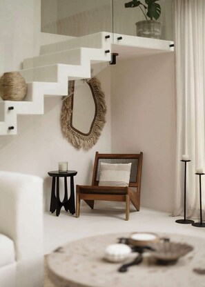 A modern interior with a staircase, a chair, a round table, and a plant. - Casa Cascada Jungle Villa Beach Club Access (Tulum)