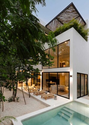 A modern two-story house with a pool, outdoor seating, and a covered patio. - Casa Cascada Jungle Villa Beach Club Access (Tulum)