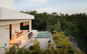 Uma casa moderna com piscina, área de estar externa e vegetação exuberante.