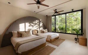 A bedroom with two beds, a curved ceiling, large windows, and ceiling fans.