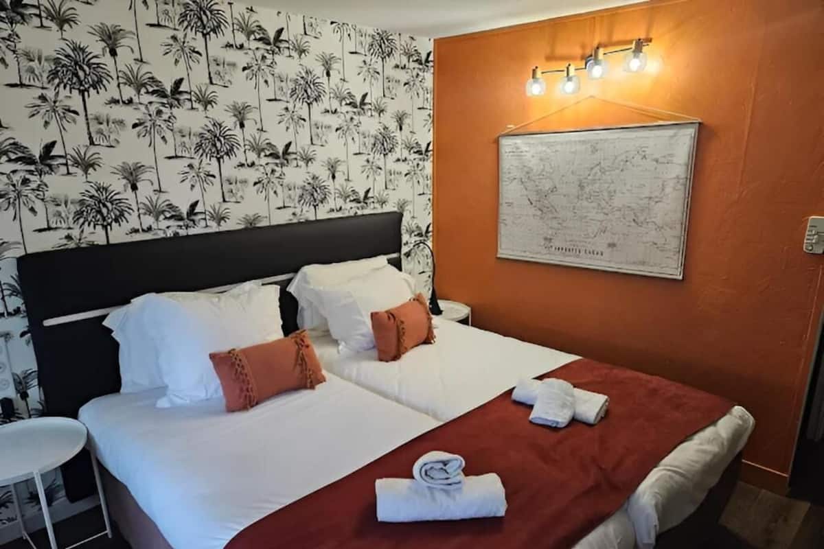 A hotel room with two beds, a map on the wall, and a small table.