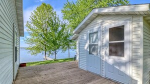 A wooden deck with a view of a lake and trees.
