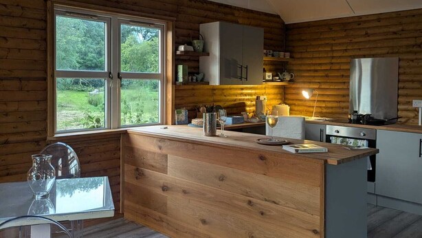 Una cocina moderna con paredes de madera, un ventanal grande y una isla central.