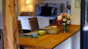 A wooden dining table with chairs, a hanging light fixture, and a vase with flowers. - Judie's garden in Schaalby (Schaalby)