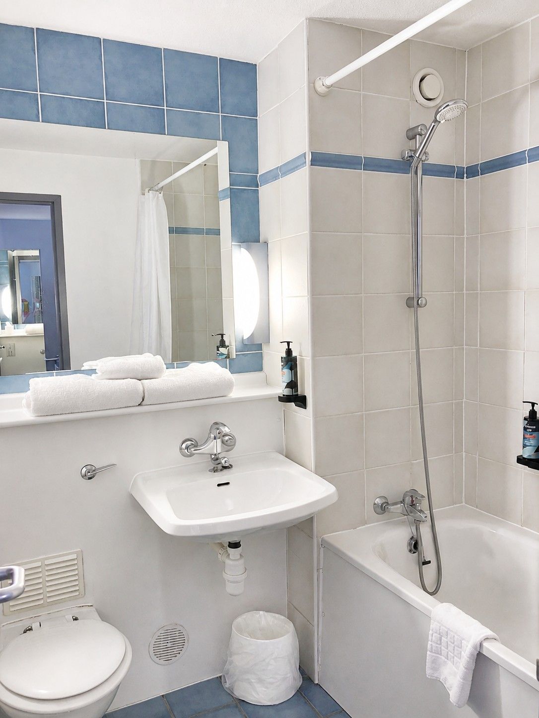 Un baño con lavamanos blanco, inodoro, bañera y ducha.
