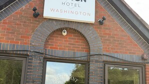 El Reston Hotel en Washington, con fachada de ladrillo, ventanas grandes y un letrero sobre la entrada.