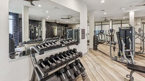 A gym with various exercise equipment, including dumbbells, treadmills, and weight machines.