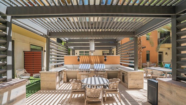 An outdoor patio with a grill, seating, and a pergola structure. - Boulevard Stays Modern Roosevelt Row Suite 2BR Pool, Gym 5 (Phoenix)