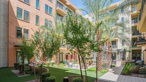 A courtyard with artificial grass, seating areas, and palm trees. - Boulevard Stays Modern Roosevelt Row Suite 2BR Pool, Gym 5 (Phoenix)