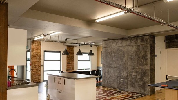 A modern kitchen with a central island, pendant lighting, and a large window. - McMillan Student Village in London (London)