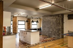 Une cuisine moderne dotée d’un îlot central, de luminaires suspendus et d’une grande fenêtre.