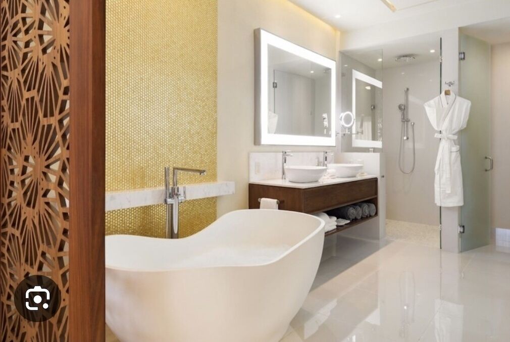 A modern bathroom with a freestanding bathtub, a large mirror, and a walk-in shower.