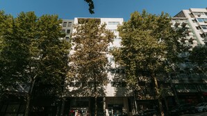 Um edifício com vários andares e arquitetura moderna, com varandas e amplas janelas.