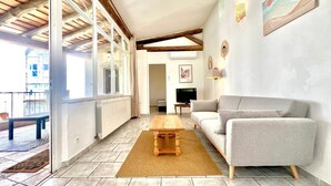 Un amplio espacio de estar con un sofá, una mesa de centro de madera y un televisor.
