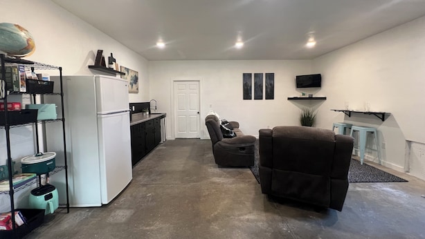A compact living space with a kitchenette, a seating area with a sofa and armchair, a television, and a door. - Lovely 2-bedroom apartment with mountain views in Anaconda (Anaconda)