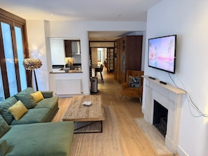 Un salon moderne avec un canapé, une table basse, une cheminée et un téléviseur.