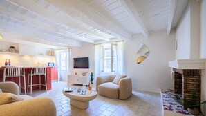 Un salon avec une cheminée, un coin cuisine et un espace repas.