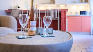 Une table avec une bouteille de vin, deux verres à vin et deux sous-verres.