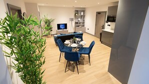 Una sala moderna con comedor, televisor y cocina.