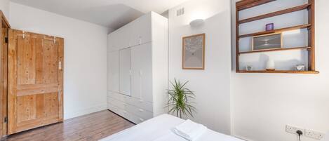 Tabla de planchar con plancha, internet y ropa de cama