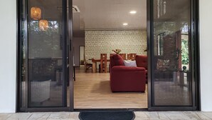 Ein modernes Interieur mit einem roten Sofa, einem Holzesstisch und einer Wand mit Muster.