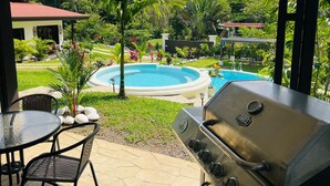 A patio with a grill, a swimming pool, and lush greenery. - Peaceful Private Villa Perfect for Groups & Families. (Alajuela Province)