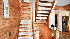Un interior de madera con una escalera en espiral y una zona de cocina.