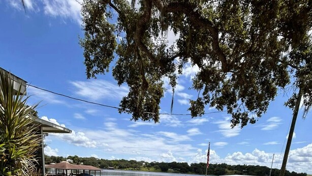 Une propriété située au bord du lac, dotée d’un quai couvert, d’une allée pavée et offrant une vue sur le lac.