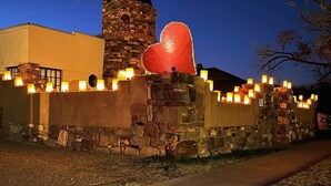 A stone building with a tower and a heart-shaped structure on top.