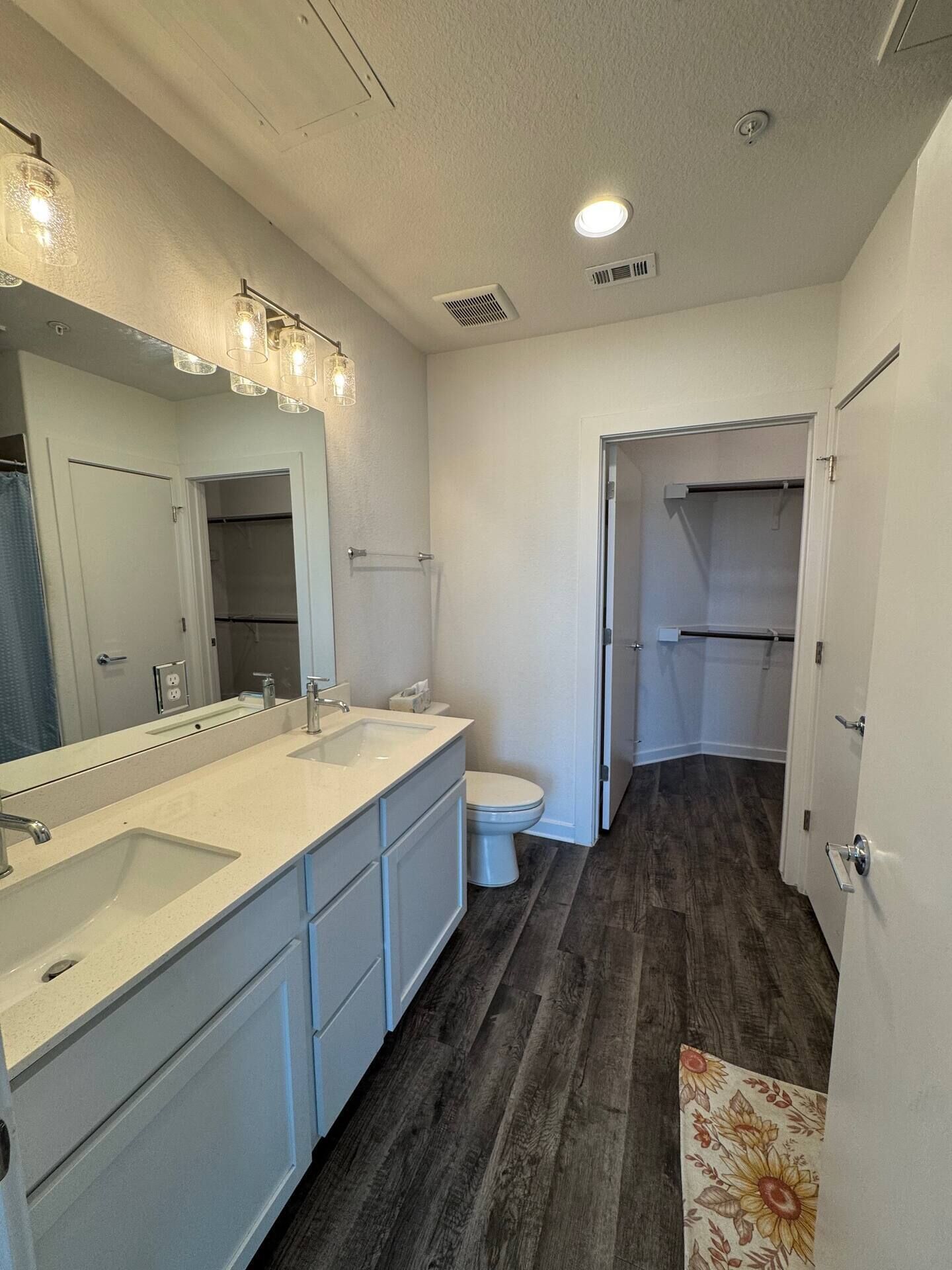 A modern bathroom with a large vanity, a toilet, and a shower area.